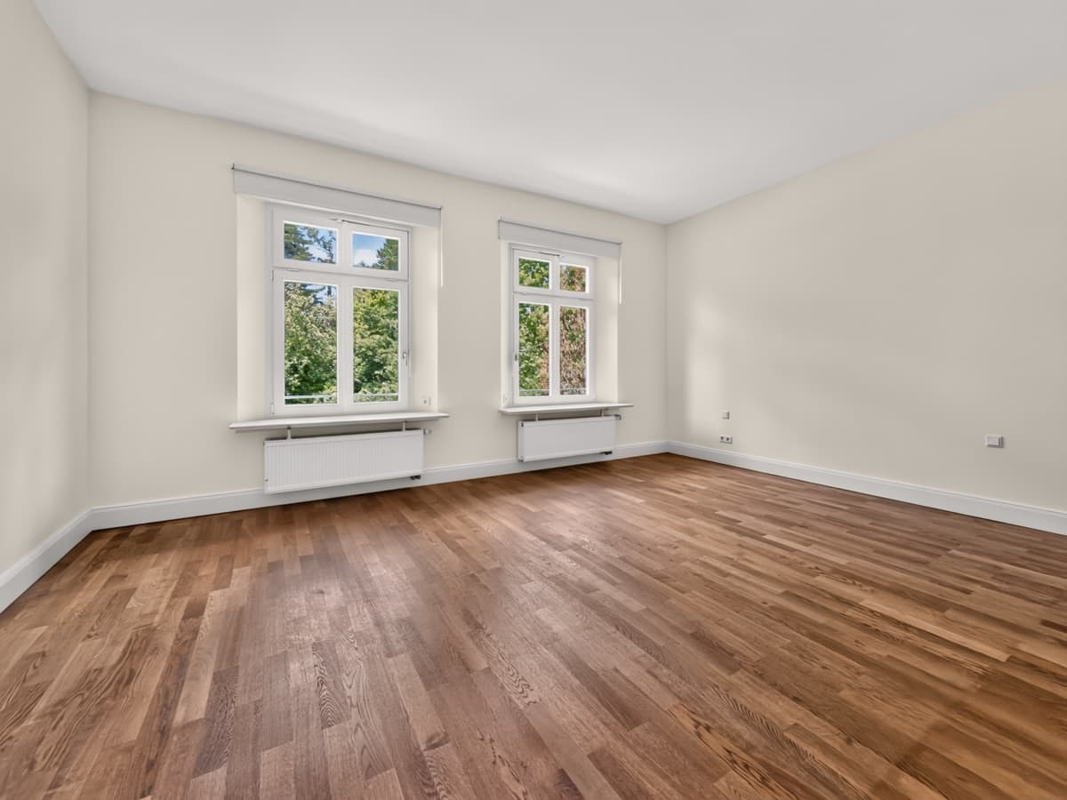 Leeres Schlafzimmer mit Parkett und zwei Fenstern — vor dem Homestaging